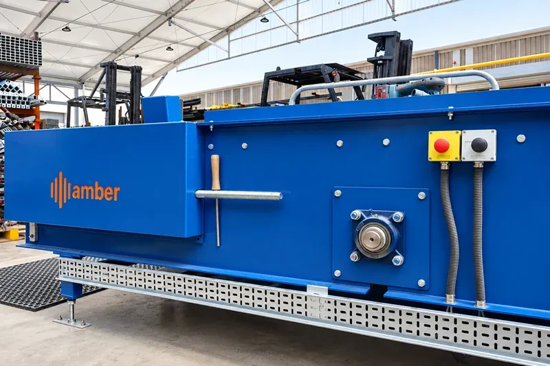 Close-up of Amber Industries blue conveyor equipment showing drive components and emergency stop controls