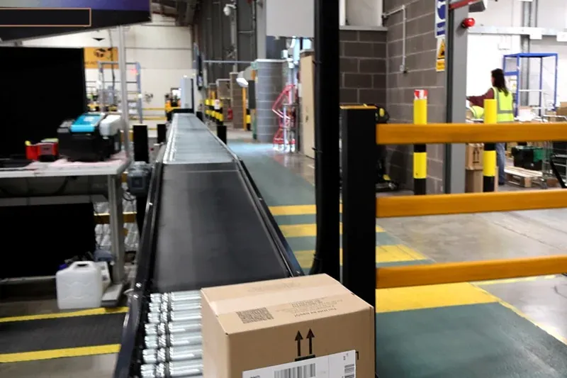 Instalación de transportador de rodillos de eje largo para el transporte de cajas a través de una instalación de distribución.